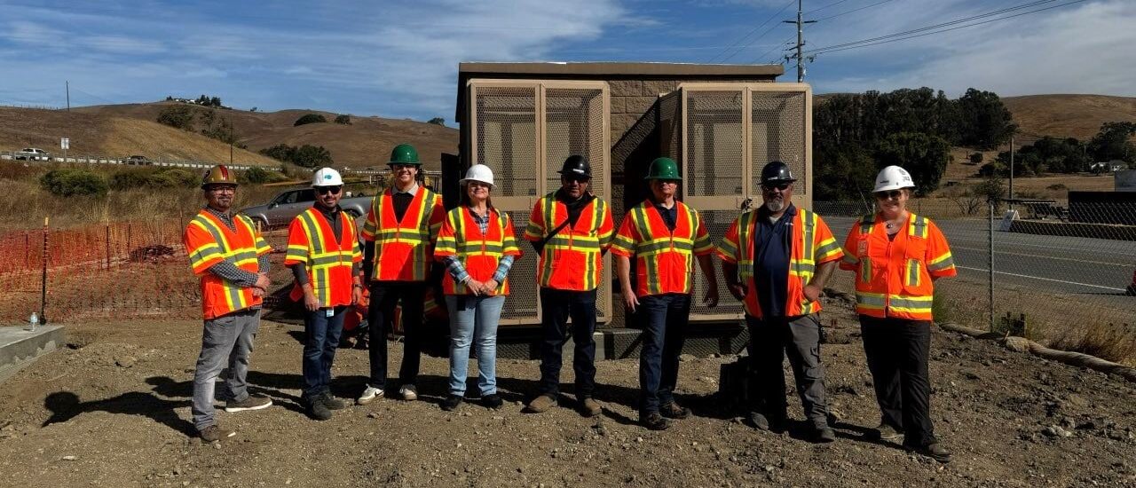 Soar staff and project partners gather at a broadband hut site.